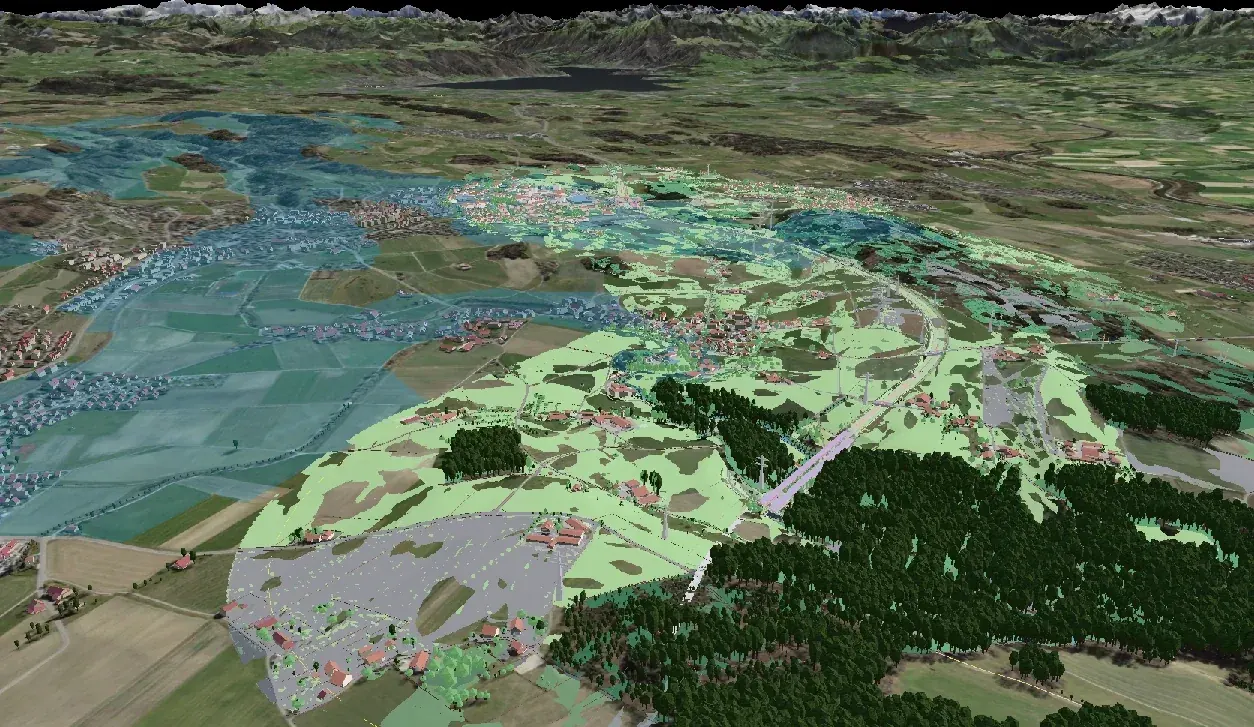 Schrägblick über das Knonaueramt bis zu einem See und den Alpen am Horizont: Gelände mit Luftbild, Häuser als 3D-Körper, Wald als dunkelgrüne Baumkörper. Im Vordergrund das Bestandesmodell der Autobahn mit hellgrünen Flächen, links davon ein weiter Bereich blau überlagert als zugeschaltetes GIS-Thema.