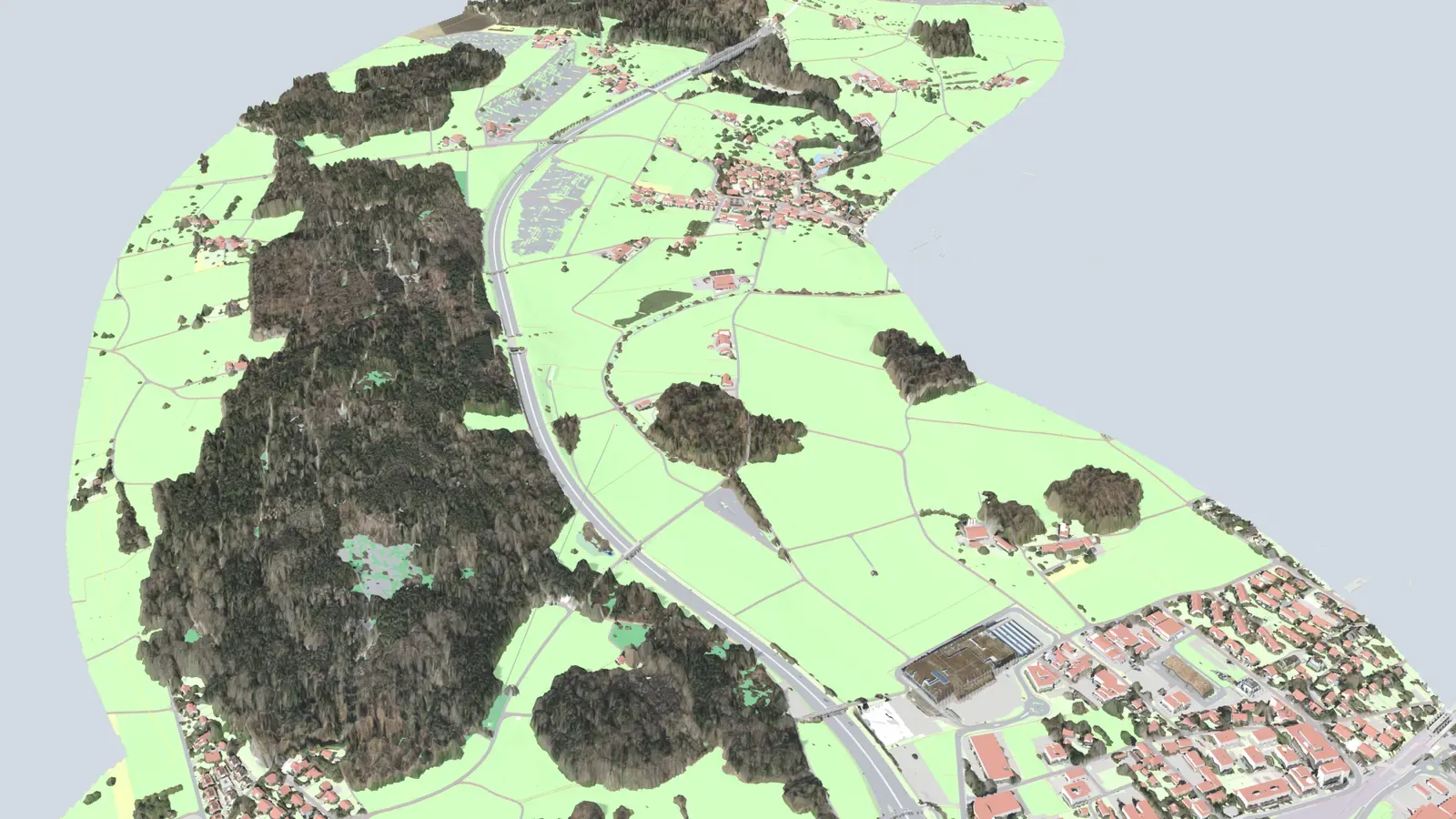 Über das Luftbild legen sich die Flächen der amtlichen Vermessung in ihren Katalogfarben — Wiese und Acker grün, befestigte Flächen grau, dazu die feinen Linien der Liegenschaftsgrenzen. Die Gebäude stehen als Körper mit roten Dächern im Gelände.